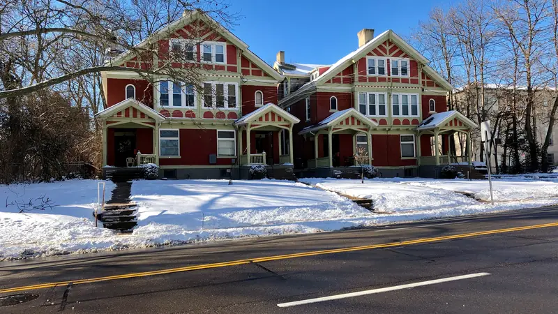 Pair of attached twin houses with red siding in winter